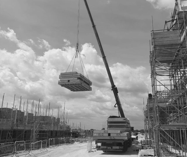 Andersons Transport on construction site with crane for wood load.